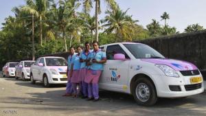 Female drivers from the 'She Taxi' service pose next to a taxi on a road in the southern Indian city of Kochi