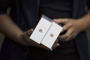 One of the first customers holds his phones as Apple iPhone 6s and 6s Plus go on sale at an Apple Store in Beijing