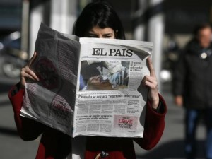 A woman poses with a first edition copy of Spanish newspaper El Pais in central Madrid